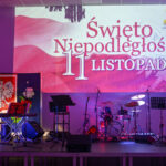 DSC_7914 Scena z instrumentami, tło z napisem Święto Niepodległości 11 listopada, dominują kolory biały i czerwony.